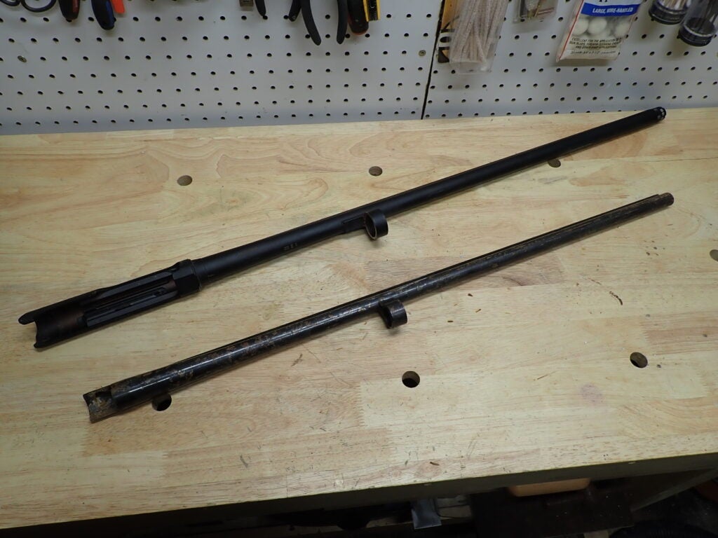 two gun barrels on a bench.