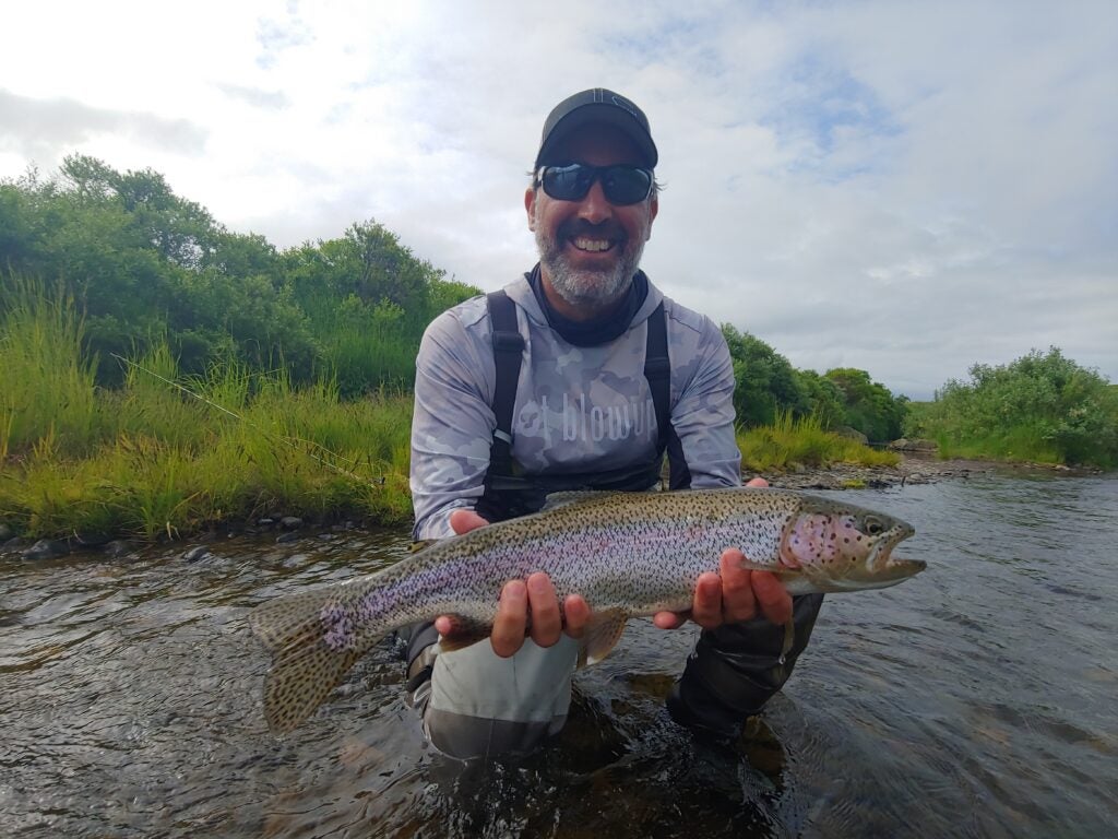 man holding rainbow trout.