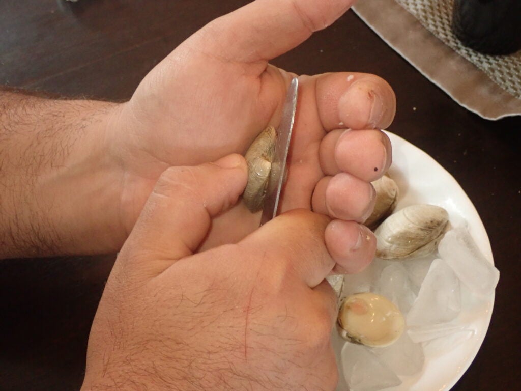 Opening clams with a knife.