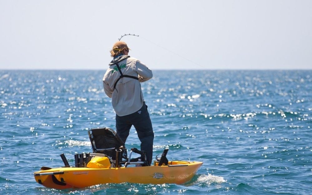 Person standing and fishing on the Hobie Pro Angler 12 kayak.
