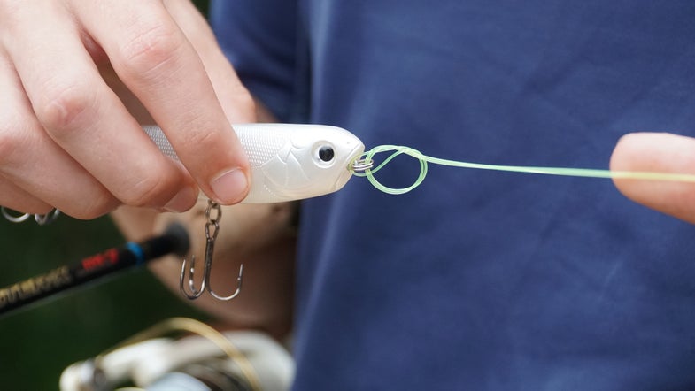 angler tying a lure on to his line with a Palomar knot