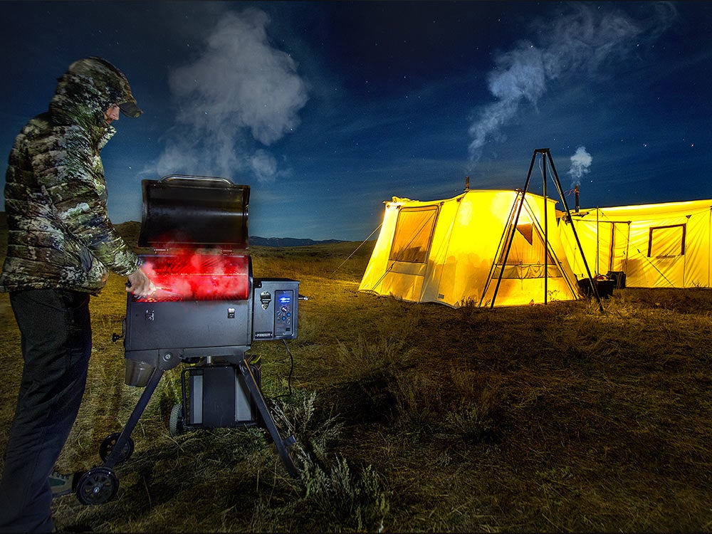 hunter cooking on a stove while wal tent hunting