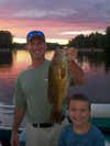 We where trolling for walleye in Gladwin Michigan. Dave Dunn was using a hot pink floating crawler harness because his wife Lisa picked the color. At first he thought he was snagged on a log. But then he felt it tug a couple times and the fight was on. The giant smallie gave an awesome air show as Ian cheered on his Dad. For northern Michigan this is a GIANT smallmouth bass! 22 1/2 inches...