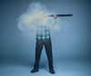 Man shooting a muzzleloader with a cloud of smoke obscuring his face. 