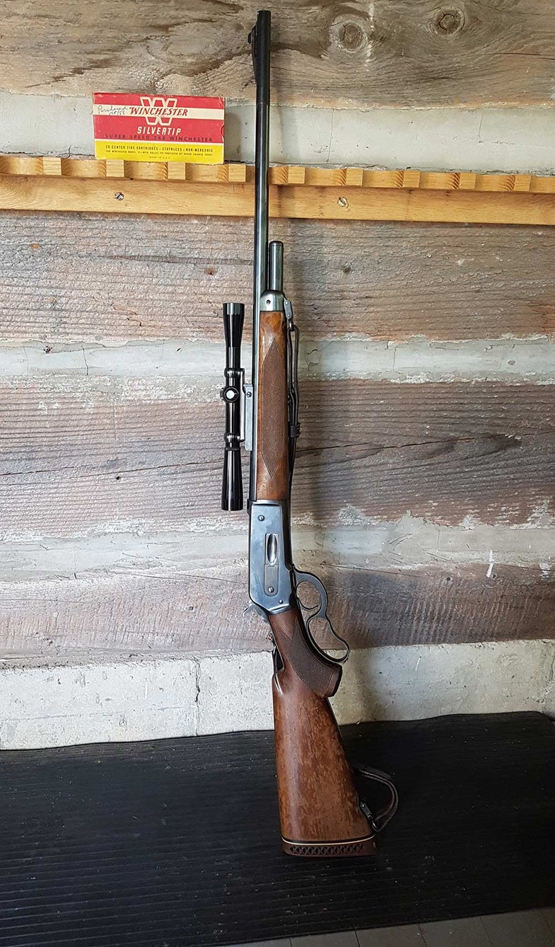 a vintage winchester model 71 leaning against the wall