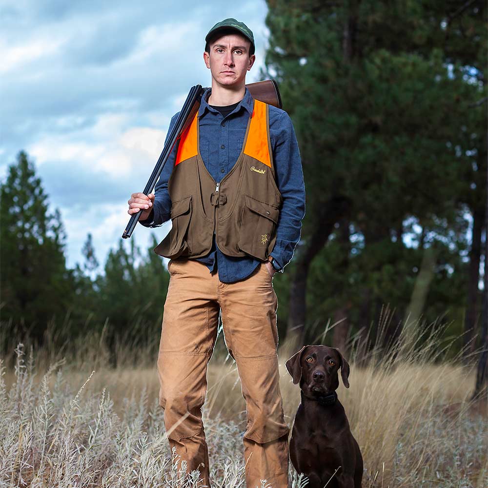 brock mickelsen with dog in a wooded field