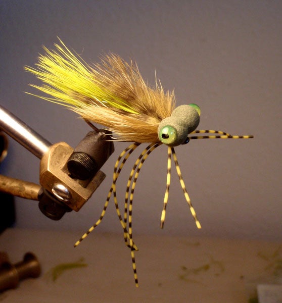 <strong>Booby Frog Recipe:</strong><br />
Hook: Gamakatsu B10S Size 2<br />
Thread: Danville's 3/0 Waxed Monocord (Dark Gray)<br />
Body Bottom: Marabou (Cream) Wapsi (MB002)<br />
Body Middle: Marabou (Golden Olive) Hareline Dubbin, Inc. (M8BQ159)<br />
Body Sides: Mink (or Squirrel) Zonker Strips (Olive Brown) Wapsi (MKZ089)<br />
Body Top: Grizzly Marabou (Olive) Hareline Dubbin, Inc. (GRIZM263)<br />
Foam Eyes: Rainy's Olive Foam Boobie Round Eyes X-Large (BE-09144)<br />
Legs: Montana Fly Centipede Legs (Speckled Yellow Medium) (0-5-125-807-2)<br />
Hard Eyes 1: Loon Outdoors UV Fly Paint (Yellow)<br />
Hard Eyes 2: Black Sharpie Marker<br />
Hard Eyes 3: Loon Outdoors UV Fly Finish (Clear) (Or UV Knot Sense)