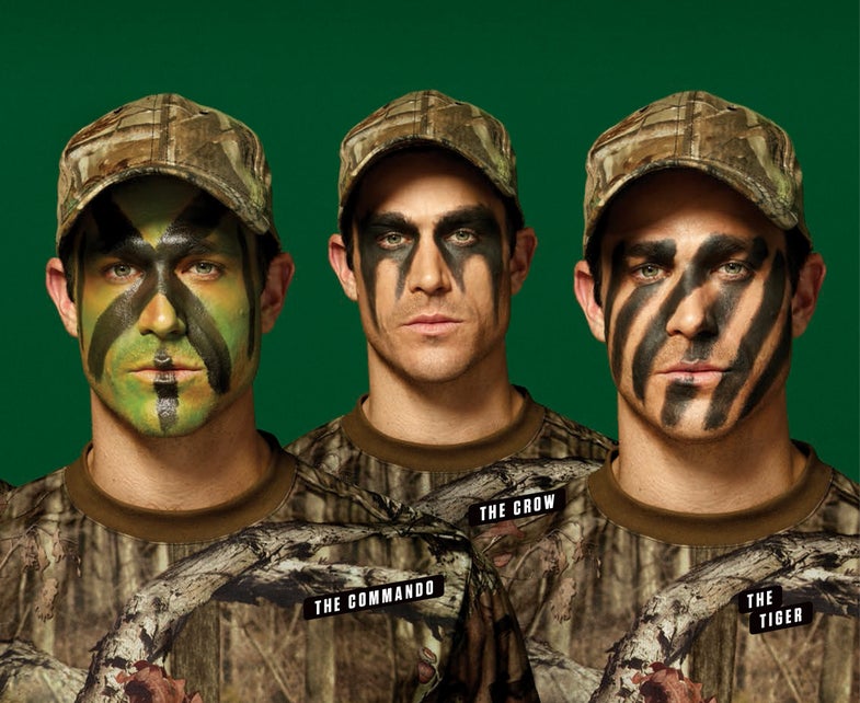 Three models pose with camouflage face paint.