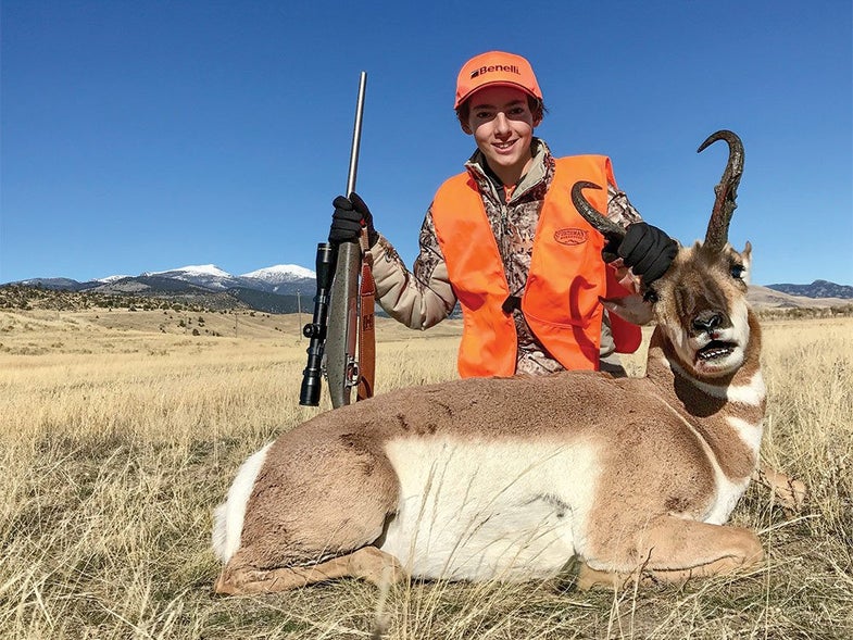 young hunter next to antelope