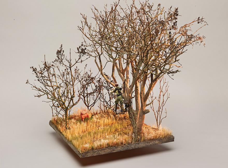 Diorama of a deer hunter in a treestand. 