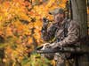 Hunter calling buck from tree stand