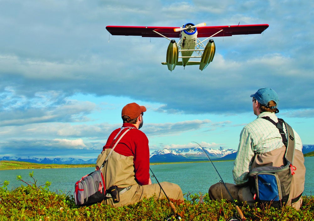 Fishing guides Aaron ­Rogers-​Richter (right) and Josh "Spud" Fitz were dropped off at the edge of this pond, between Katmai National Park and Becharof National Wildlife Refuge, by the de Havilland Beaver floatplane over their heads last August. They sat to watch it fly out and take in the scenery before continuing on a 20-minute hike to a sweet spot for grayling, rainbow and Dolly Varden trout, and king salmon. "As the plane flew over, we could feel the vibrations from head to toe," says Rogers-Richter,<br />
who travels eight to 10 months of the year in search of exceptional waters. "It was a spectacularly beautiful day in one of the most wild places that are left in the world."<br />
<strong>Location:</strong> Alaska peninsula<br />
<strong>Issue:</strong> July, 2012<br />
<em>Photo by Brian Grossenbacher</em>