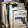 stacks of old books and gun reference manuals