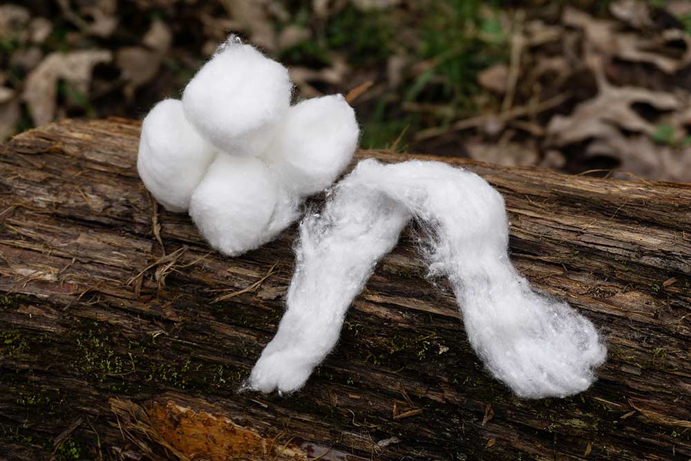 balls of cotton on a wooden log
