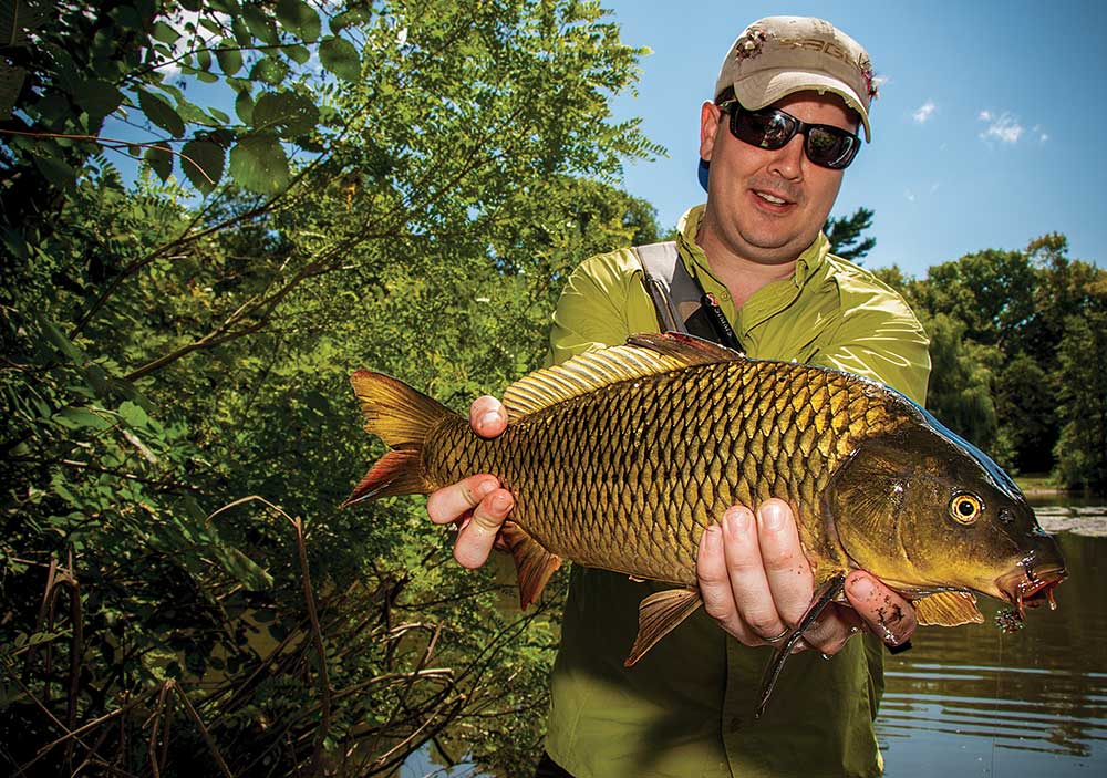 A fly angler admires his first-ever carp caught.