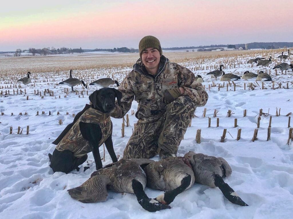 How to name your dog: hunter alex robinson kneeling behind canada geese with a black lab