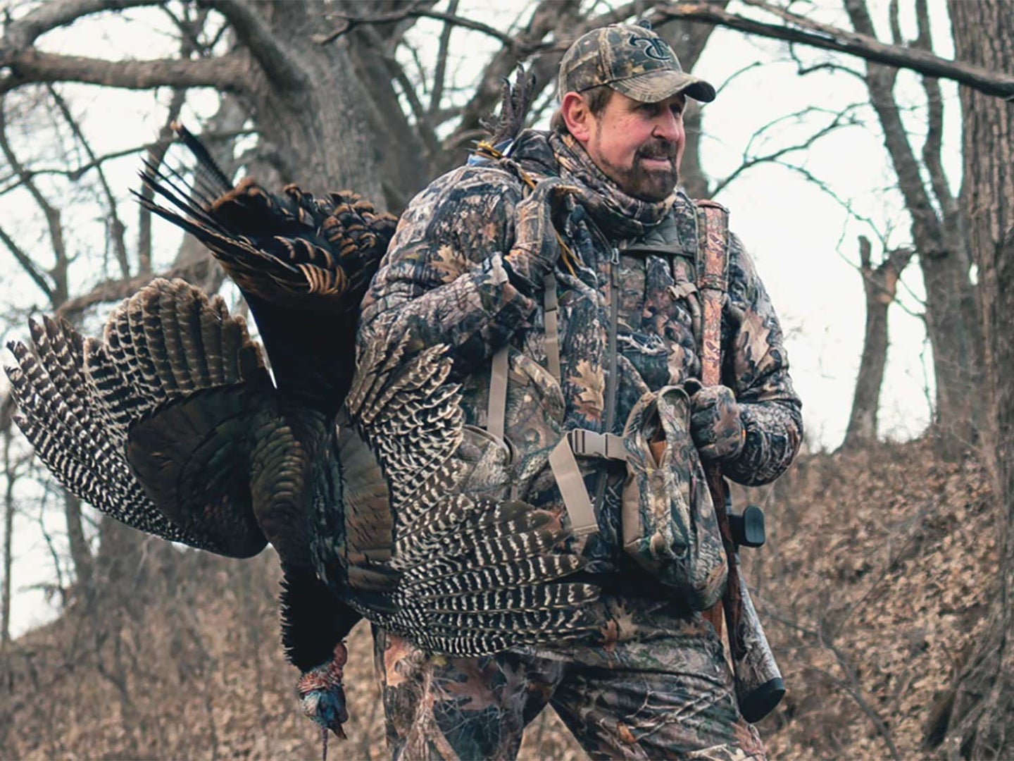 turkey hunter with a turkey over the shoulder