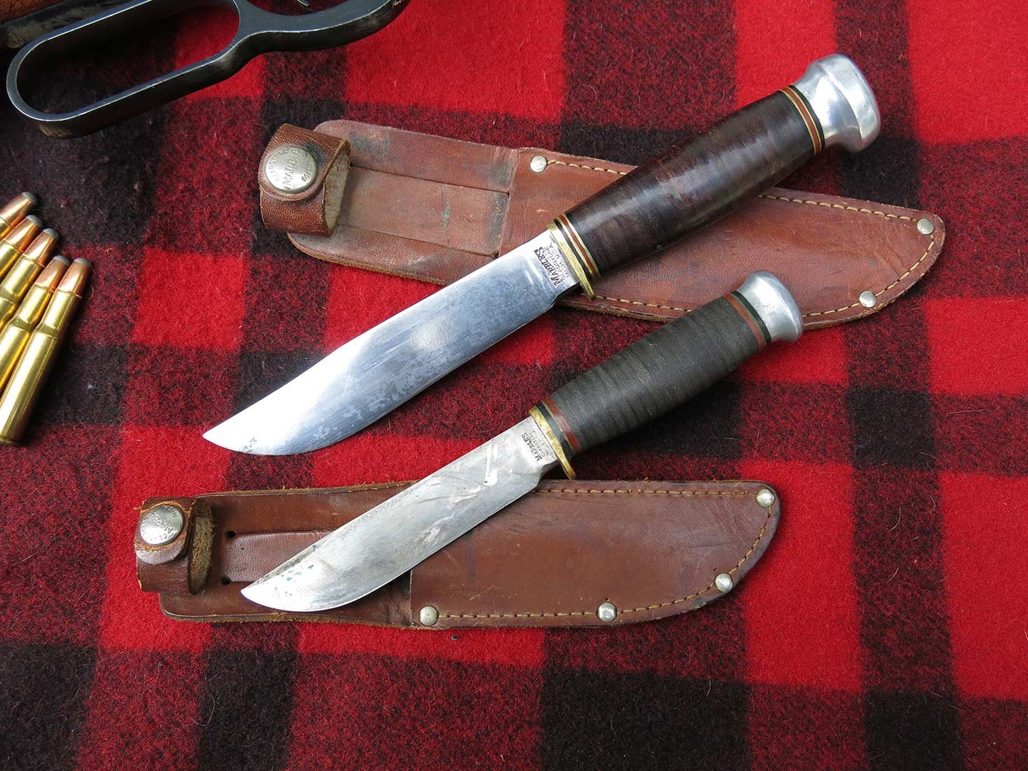 two hunting knives and sheathes