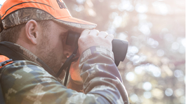 Hunter using a pair of Bushnell Prime hunting binoculars in the field