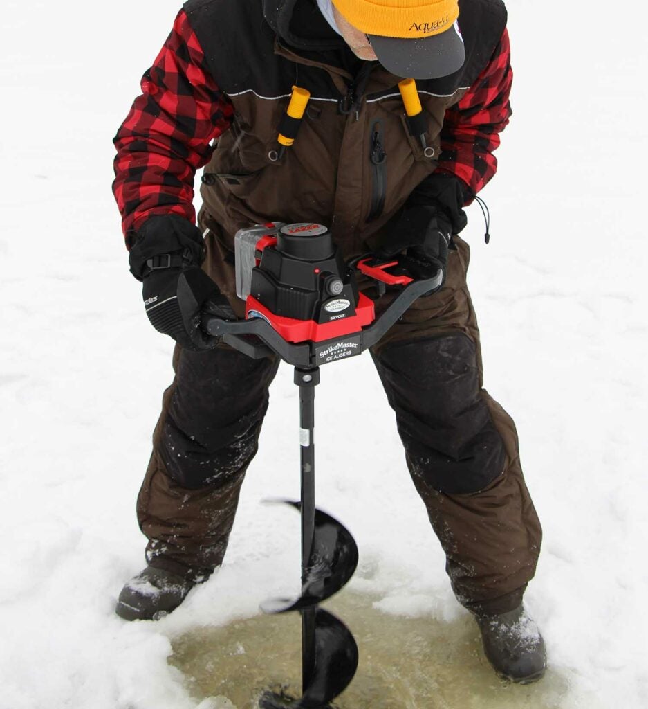 Man using auger to drill a hole in ice.