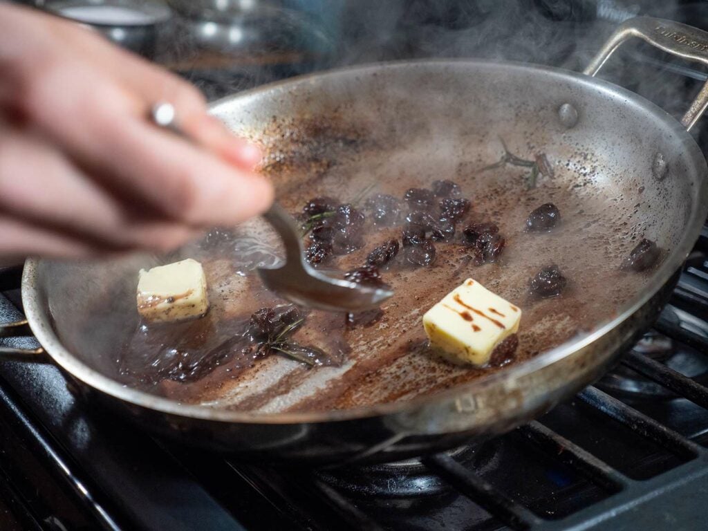 Making a reduction sauce in a pan for seared venison.