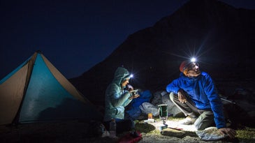 Campers using Black Diamond Headlamps at a campsite at night.