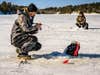 Anglers ice fishing on a lake.