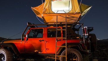 A jeep with a camping tent.