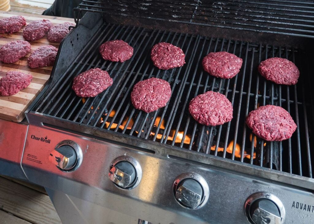Hand-formed venison patties on a grill