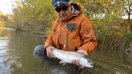 An angler with a large rainbow trout.