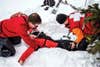 A search and rescue team pulls a person out of snow in training.