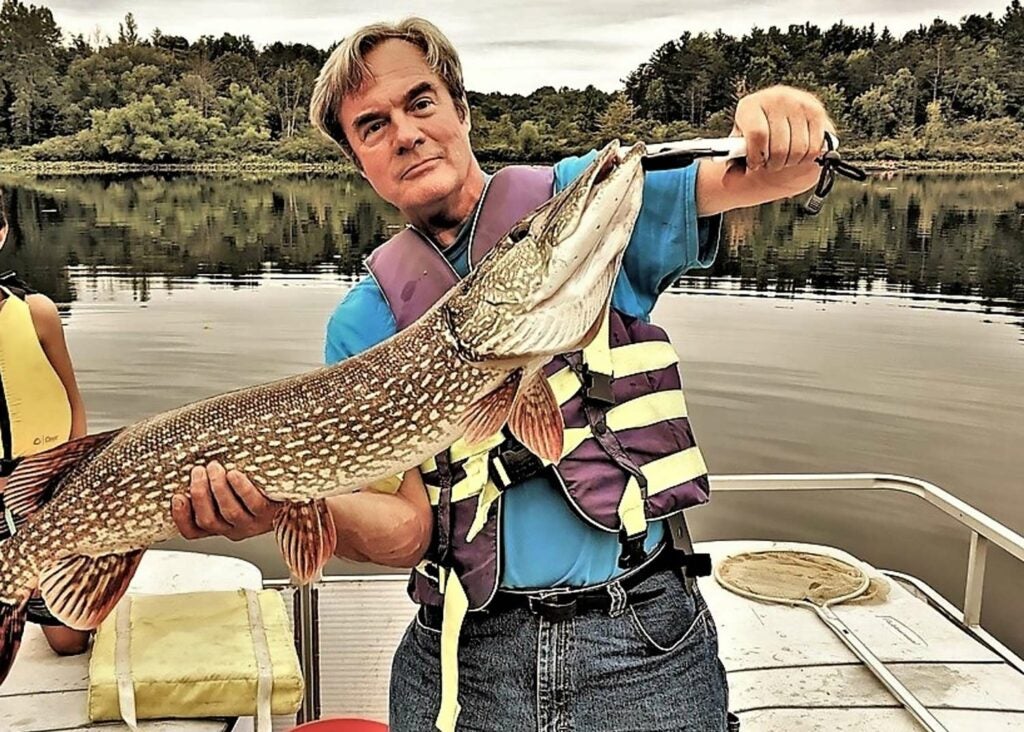 An angler holding up a large northern pike.