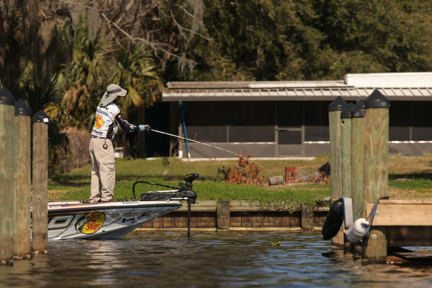 A bass angler fishing off the front of a bass boat.