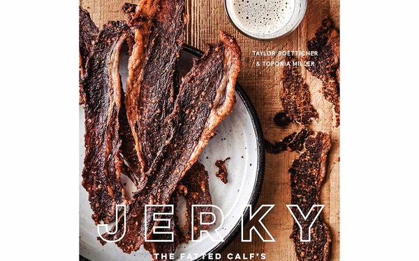 A book cover with beef jerky on a wooden table.