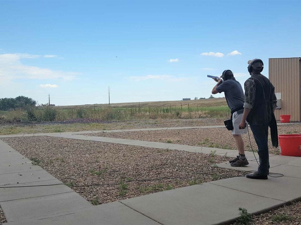 Two men trap shooting at a shooting range.