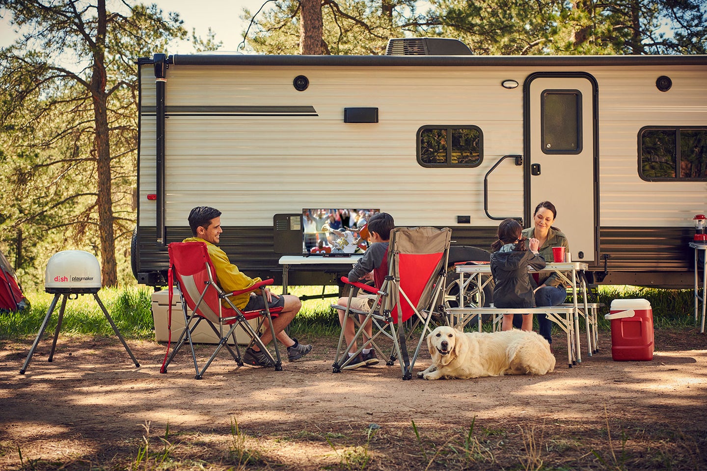 A group of campers sitting outside of an RV.