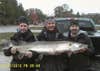 Three men holding up a large muskie fish.