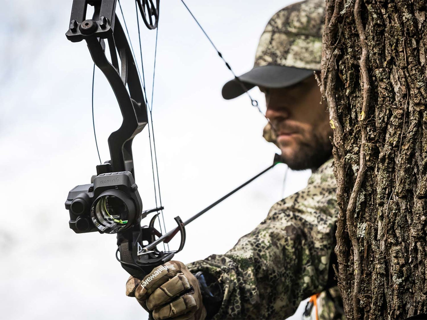 A hunter uses a compound bow fitted with a Garmin bowsight.