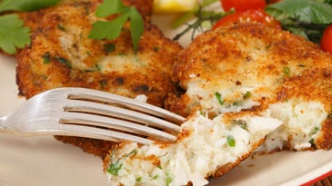 A fork cuts into a fish cake.