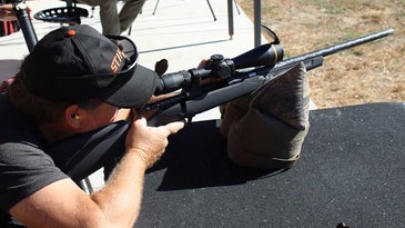 A shooter aims a rifle at a shooting range.