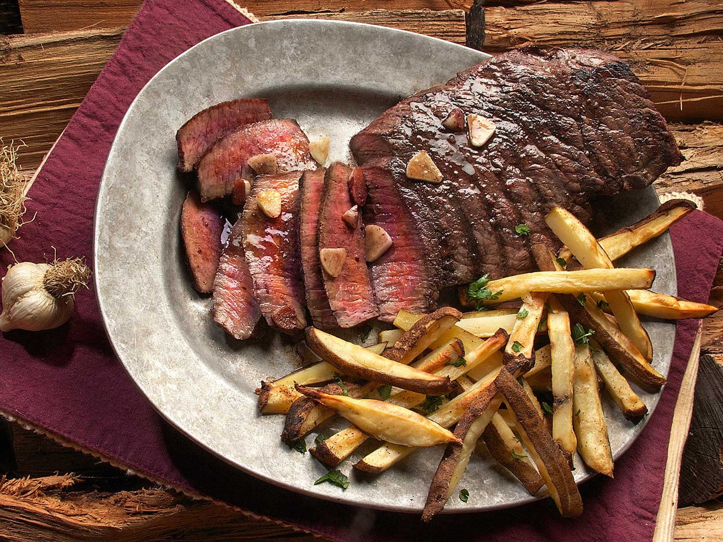 Steak and french fries on plate.