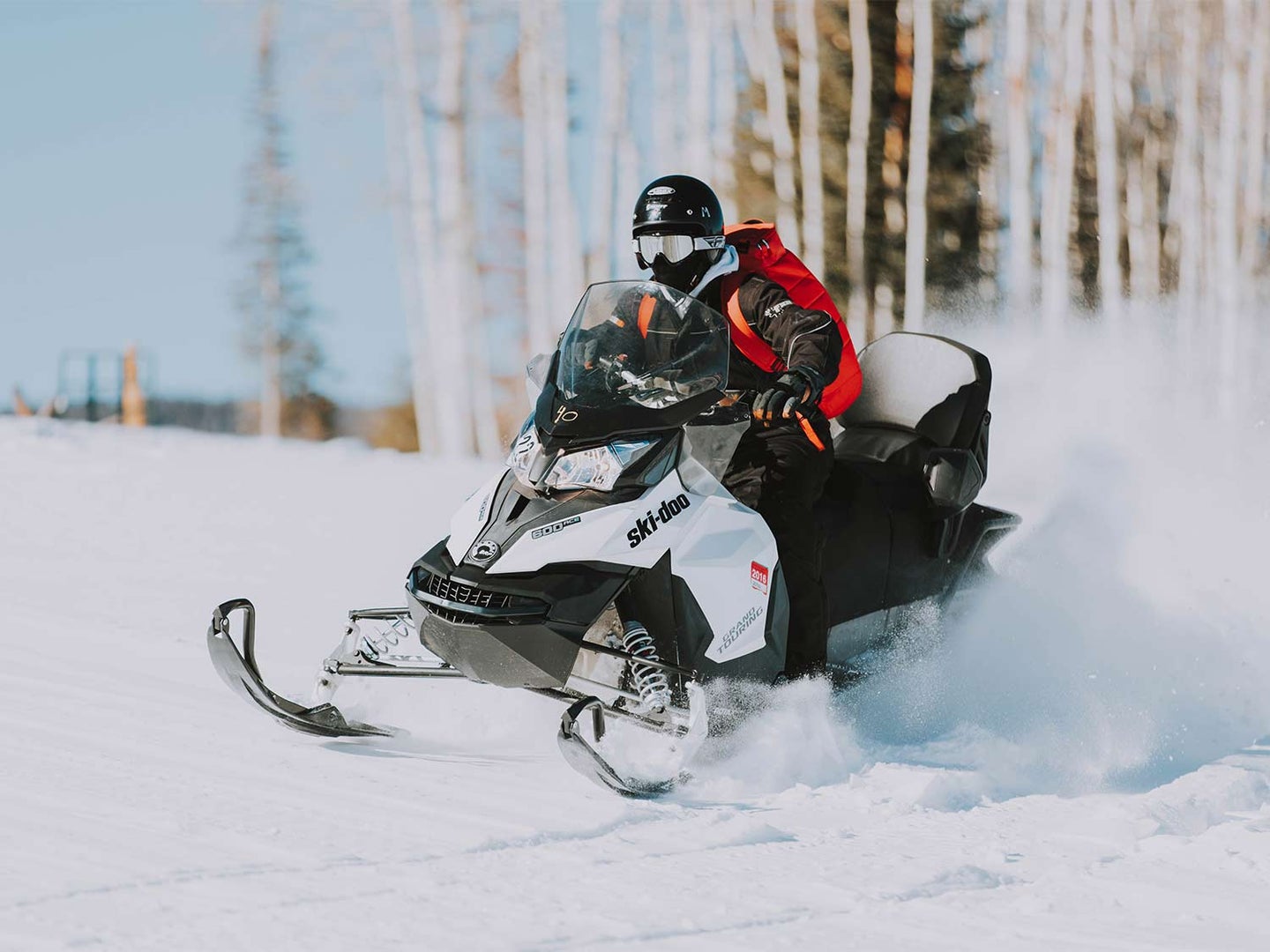 A person riding a snowmobile with the best snowmobile helmet.