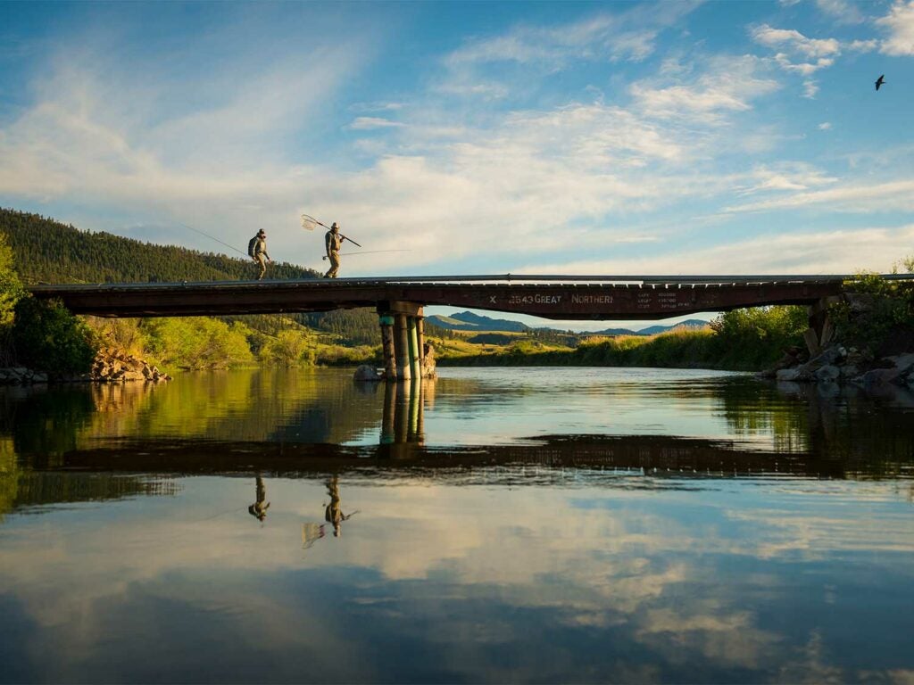 two anglers crossing a bridge over Missouri River