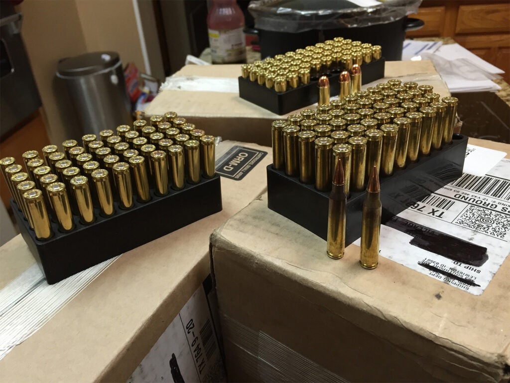 Several boxes of ammunition sitting on top of shipping boxes.