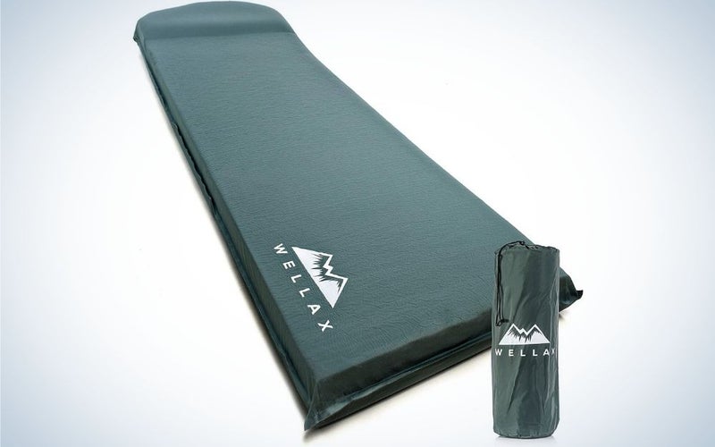 A black thick sleeping pad with the name of the firm WELLAX up to it and a black packing bag.