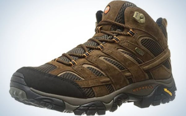 A thick and brown men's winter shoes with thick laces and a dark rubber with the Merrell logo on it.