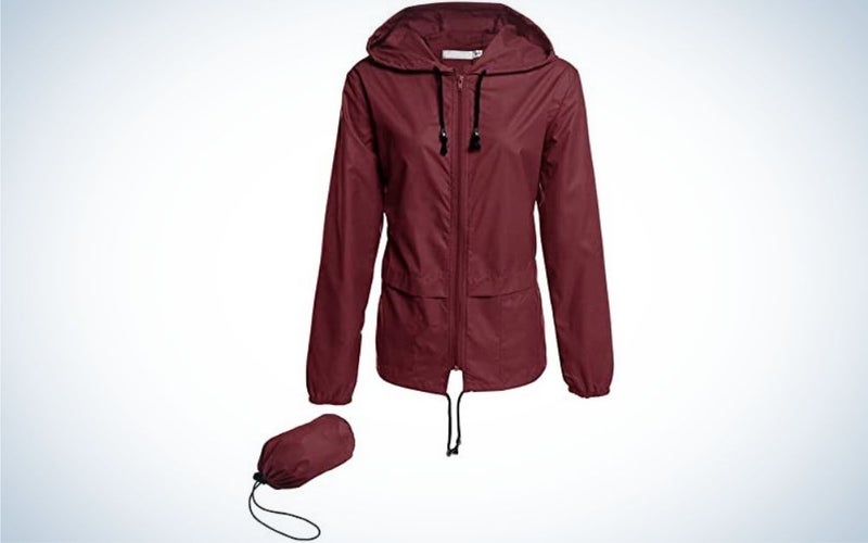 A thin jacket against the rain, cherry color and with a hood, as well as a bag for wrapping this jacket.