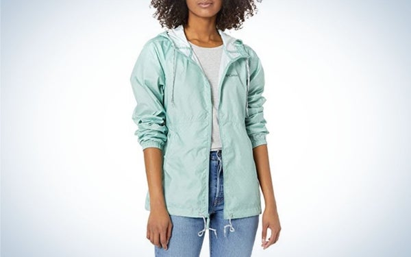 A woman posing with a light blue windbreakers jacket and wearing jeans too.