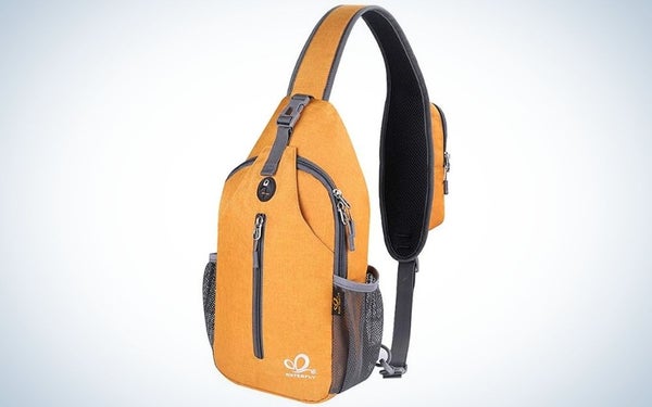 A yellow crossbody sling backpack sling bag travel hiking chest bag daypack with a center pocket with grey zipper.