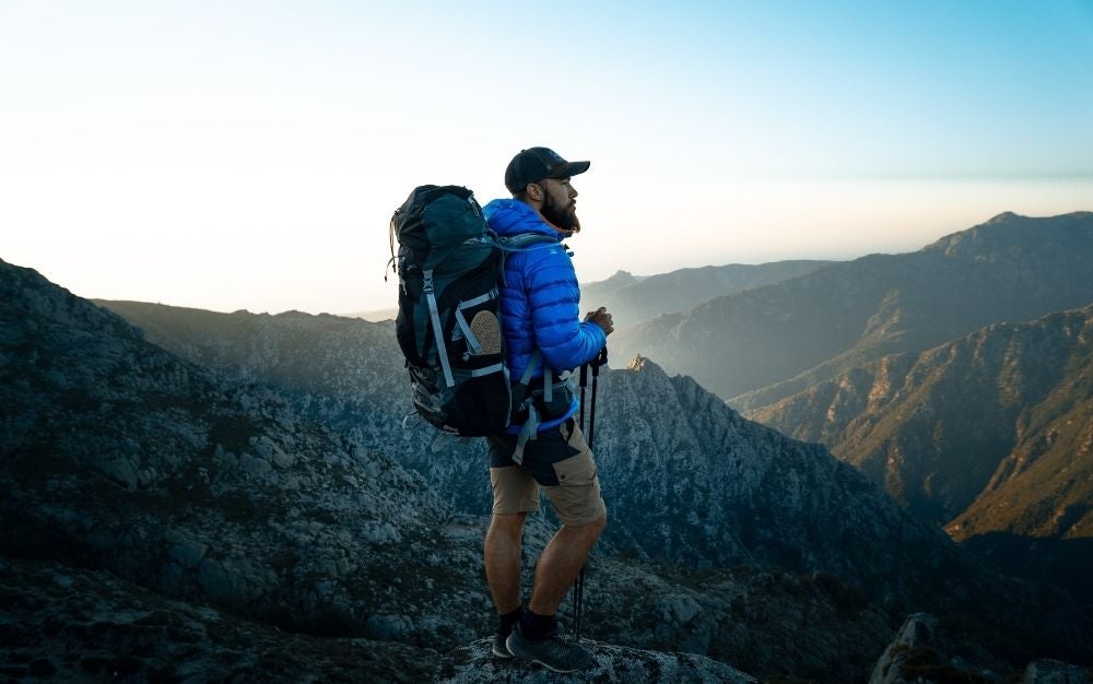 Person hiking and carrying a black and gray backpack